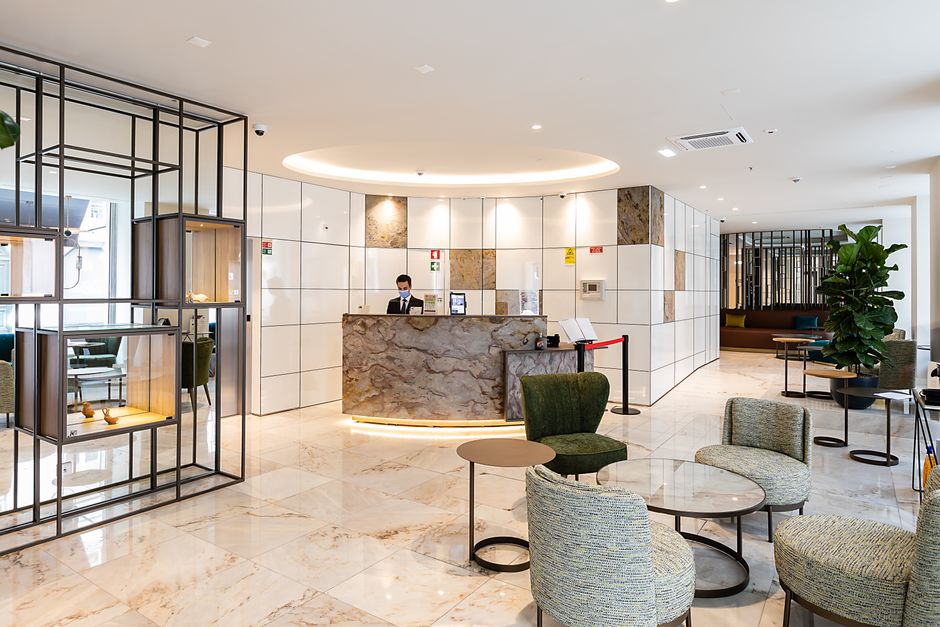 A detailed view of a hospitality lobby furniture specification, highlighting the robust construction of a custom sofa with durable upholstery and sturdy wooden legs.