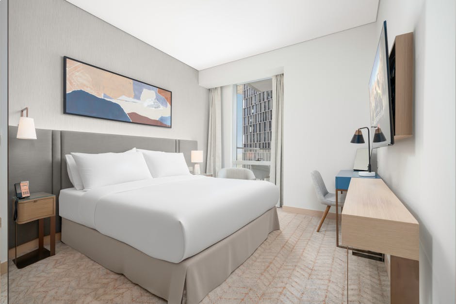 A modern hotel suite showcasing a flexible modular hospitality furniture system, with a reconfigurable sofa and a movable coffee table.