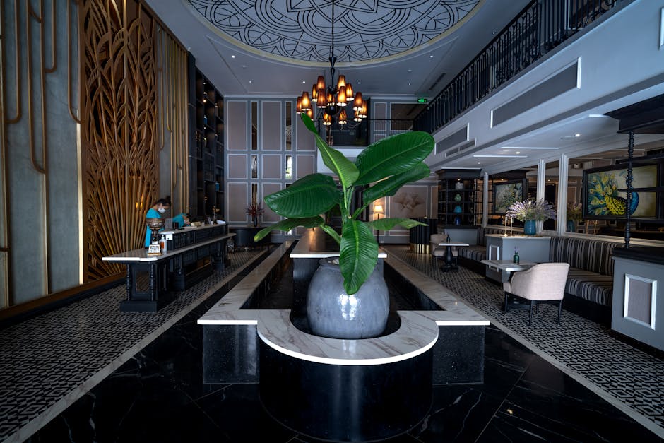 A spacious, modern hotel lobby with a well-defined hotel lobby furniture layout plan, featuring comfortable modular seating in warm tones and natural light.