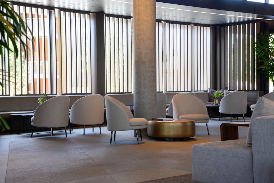 An elegant hotel lobby showcasing a thoughtful modular seating plan for hotel lobbies, with various seating arrangements for different guest activities and large windows overlooking a city skyline.