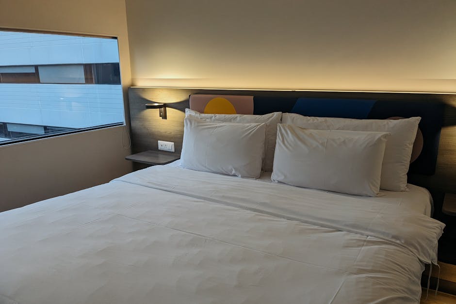 Close-up of a robust hotel bed frame constructed from FSC-certified solid wood, highlighting mortise-and-tenon joinery and reinforced corner blocks, indicative of commercial heavy duty beds for serviced apartments.