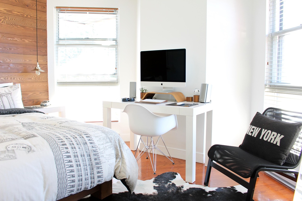 minimalist hotel guestroom with floating wooden desk and leather chair