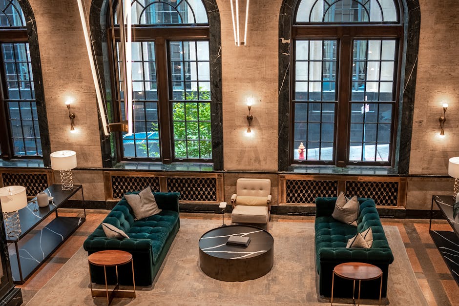 Spacious hotel lobby with stylish furniture, large windows, and contemporary lighting.
