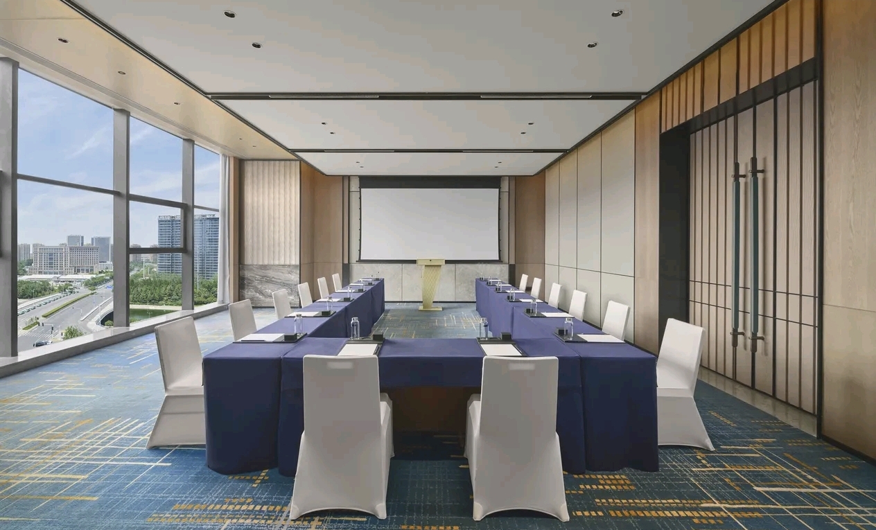 Small meeting room with blue cloth conference setup at DoubleTree Zhengzhou East