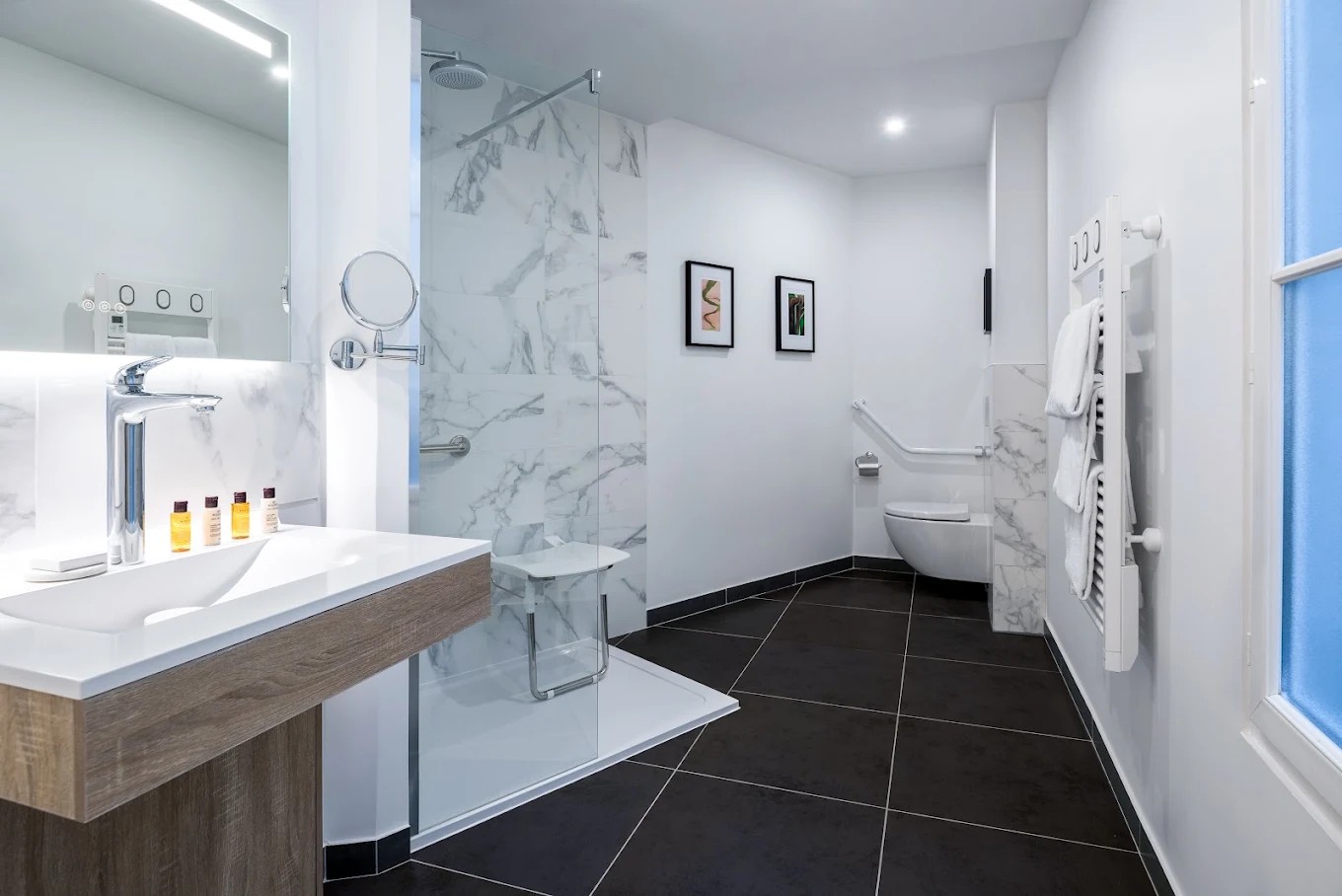 Compact dark tile guest bathroom at Hotel Camille Paris