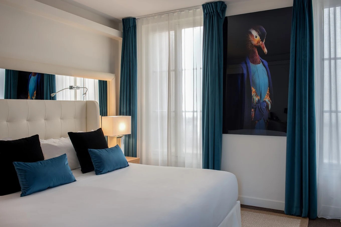 King bedroom with dark blue curtain at Hotel Camille Paris