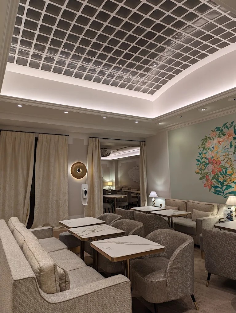 Lobby lounge zone beneath the skylight at Hotel Camille Paris