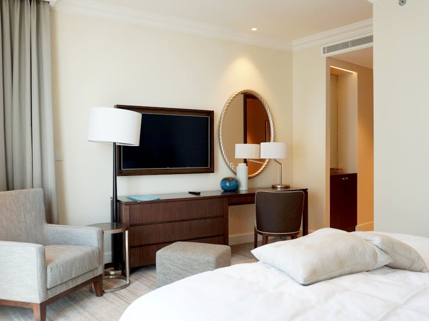 A beautifully designed hotel room featuring a TV, armchair, and elegant decor, perfect for travelers.