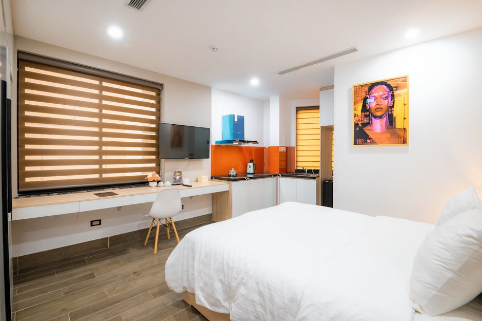 A contemporary hotel guestroom showcasing custom commercial grade bedroom furniture, including a wooden desk with a built-in lamp and USB ports.