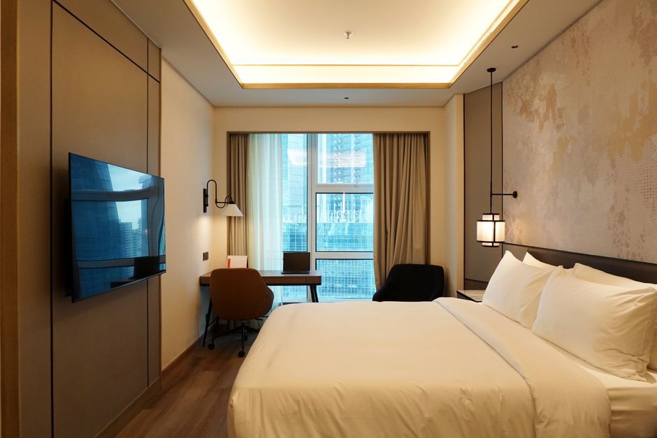 A guest room in a luxury resort, showcasing bespoke wooden casegoods with integrated charging points, a key trend in Middle East hotel furniture.