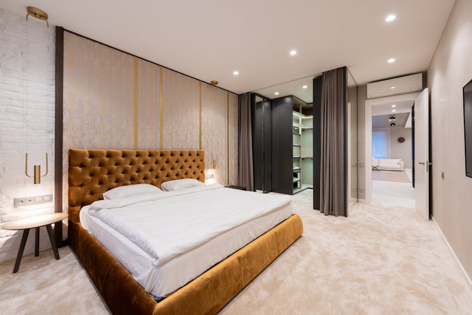 A minimalist hotel bedroom with a large headboard made from sustainable wood, integrated bedside tables, and a comfortable mattress, showcasing eco-friendly contract hotel furniture.