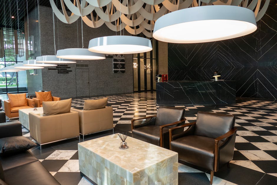A sophisticated hotel guest suite living area with a comfortable custom hotel luxury sofa, accent pillows, and a panoramic window overlooking a city skyline, emphasizing both relaxation and high-end design.