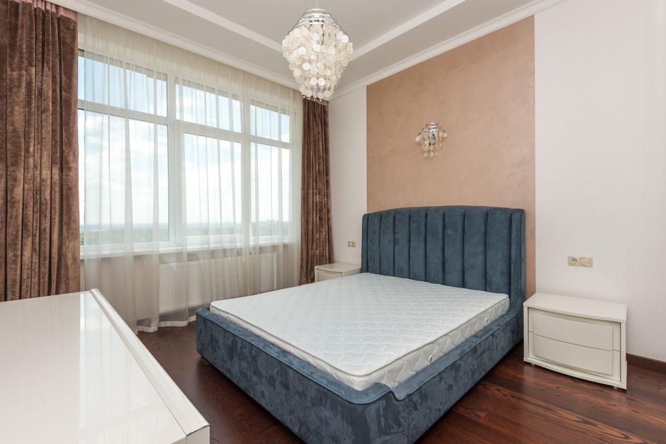 An elegant hotel suite showcasing custom hospitality bedroom casework with built-in storage, a media console, and a unique textured finish, designed for a luxury guest experience.