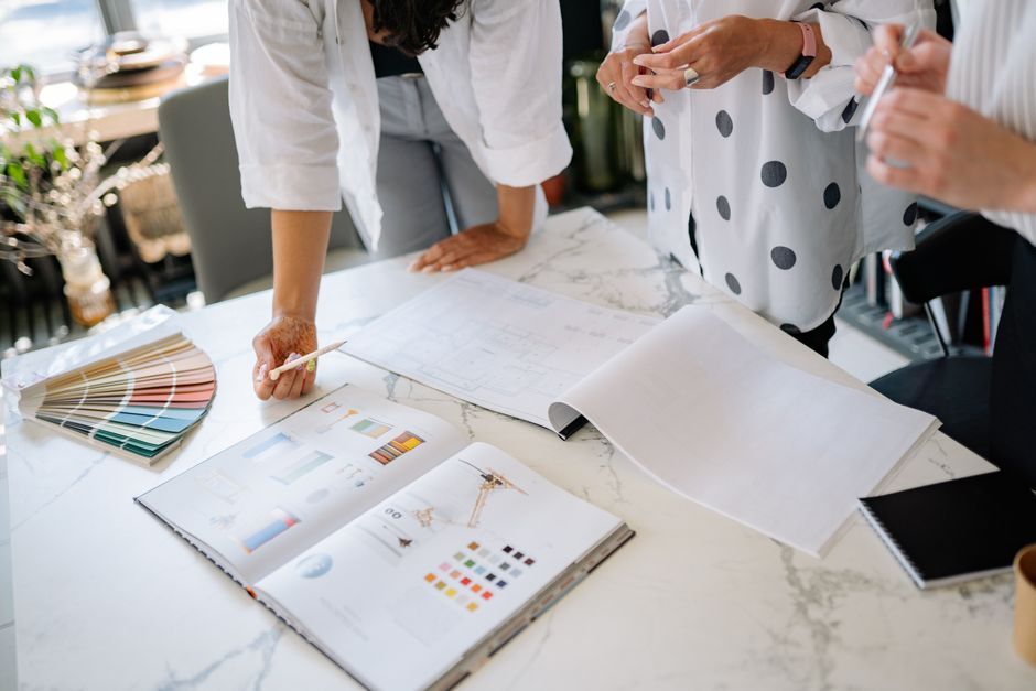 Design team working together with color swatches and plans on a table.