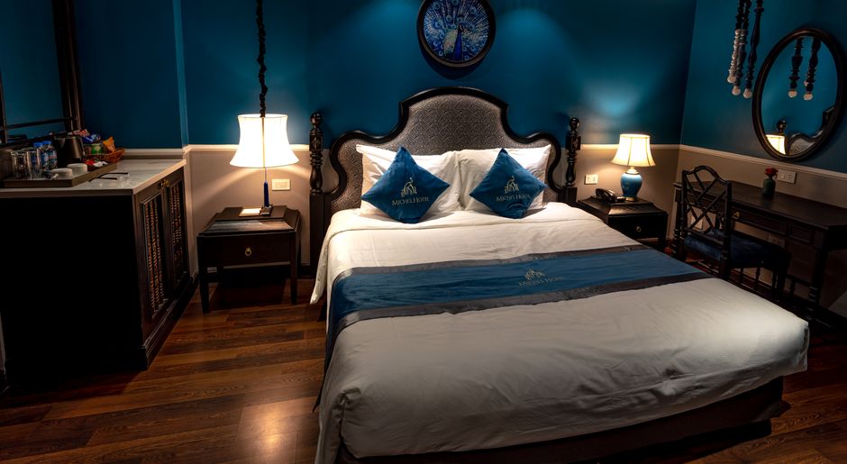 Elegant hotel bedroom featuring classic blue decor and stylish furnishings.