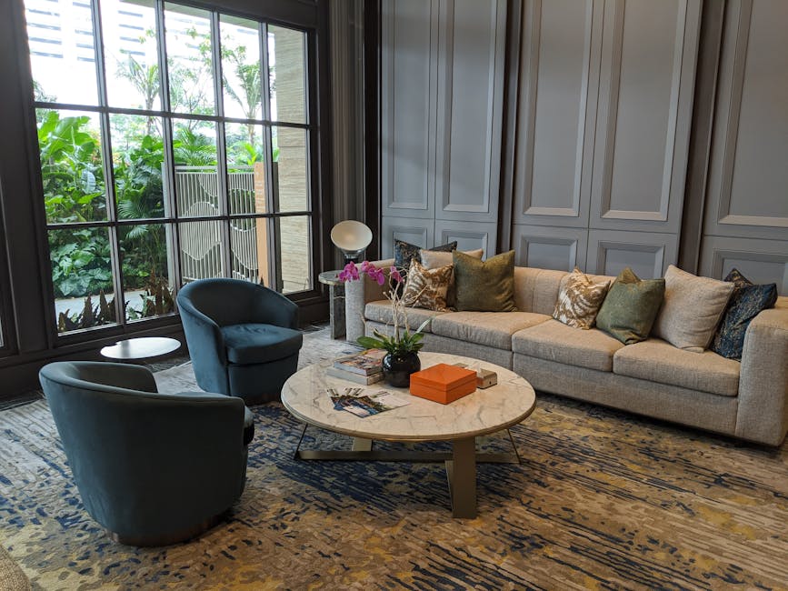 Elegant living room with chic furniture, large windows, and vibrant orchids.
