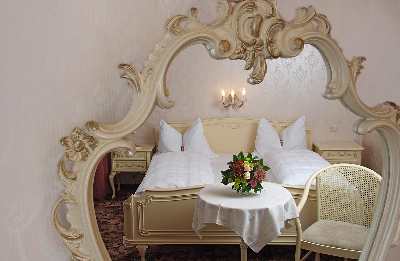 fully furnished hotel room with a neatly made bed, desk, and armchair, ready for inspection