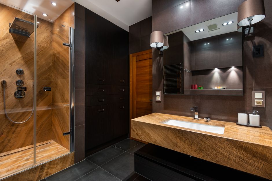 Interior of contemporary bathroom with wooden elements and black walls in modern apartment
