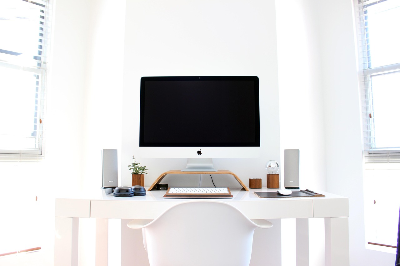 minimalist hotel guestroom with floating wooden desk and leather chair, natural light