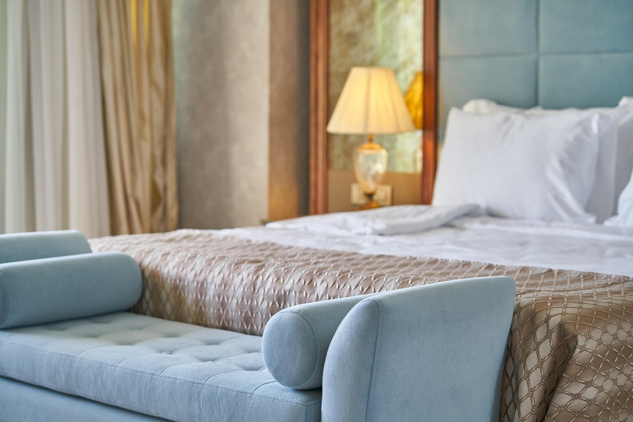 Well-appointed hotel suite demonstrating optimized hotel furniture cost per room, with a spacious seating area, a large TV console, and elegant lighting fixtures.