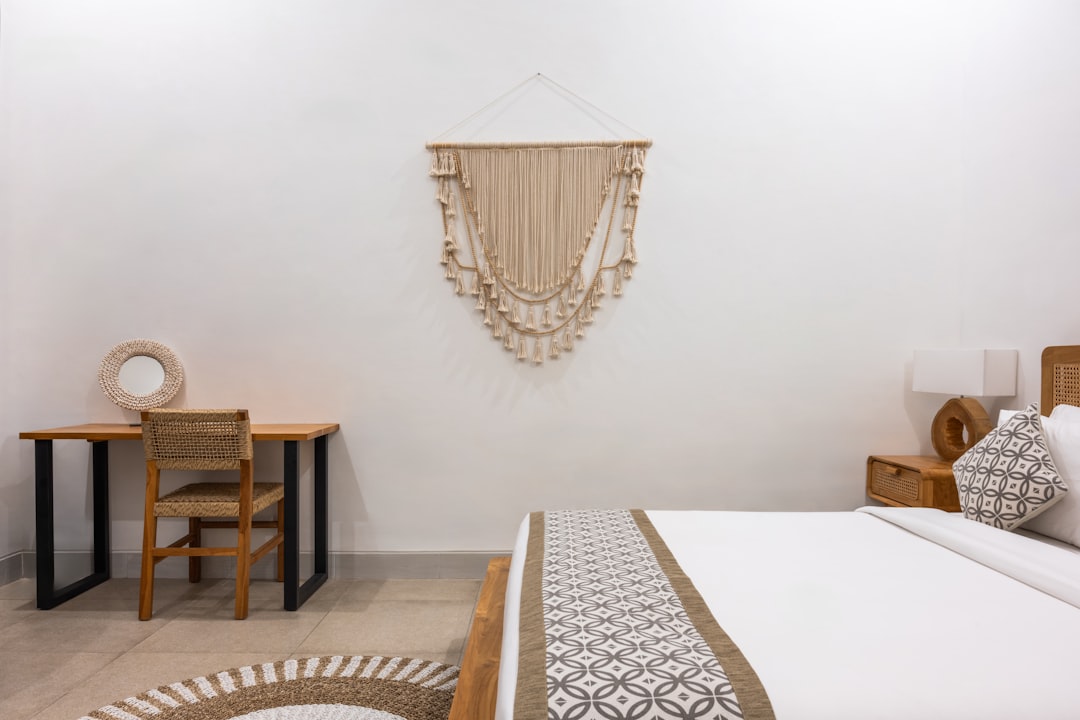A bed room with a neatly made bed and a chair