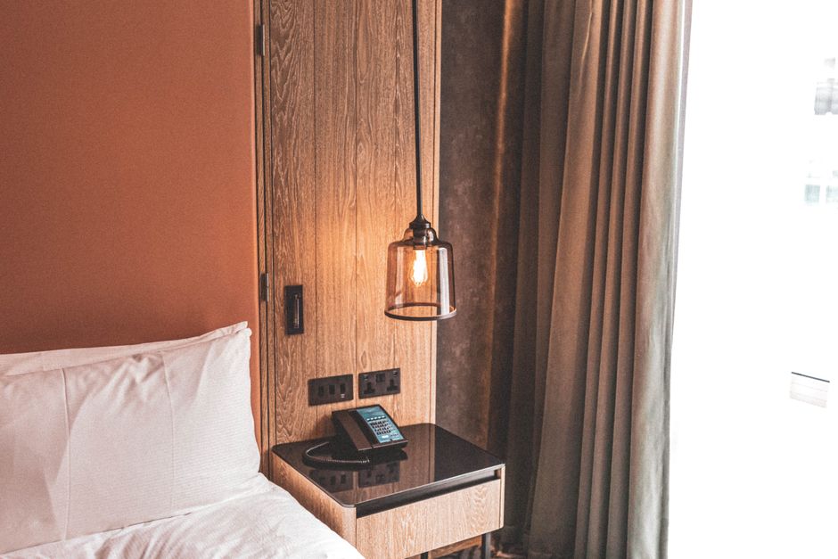A cozy and modern hotel room featuring minimalist design and warm lighting.