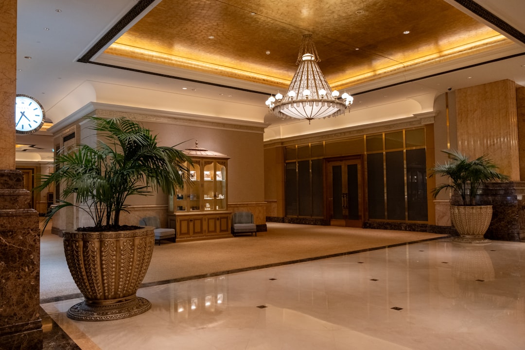 A hotel lobby with a chandelier and planters