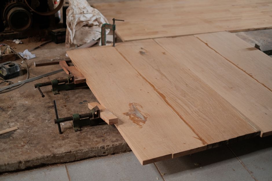 Detailed view of clamped wooden planks in a woodworking workshop.