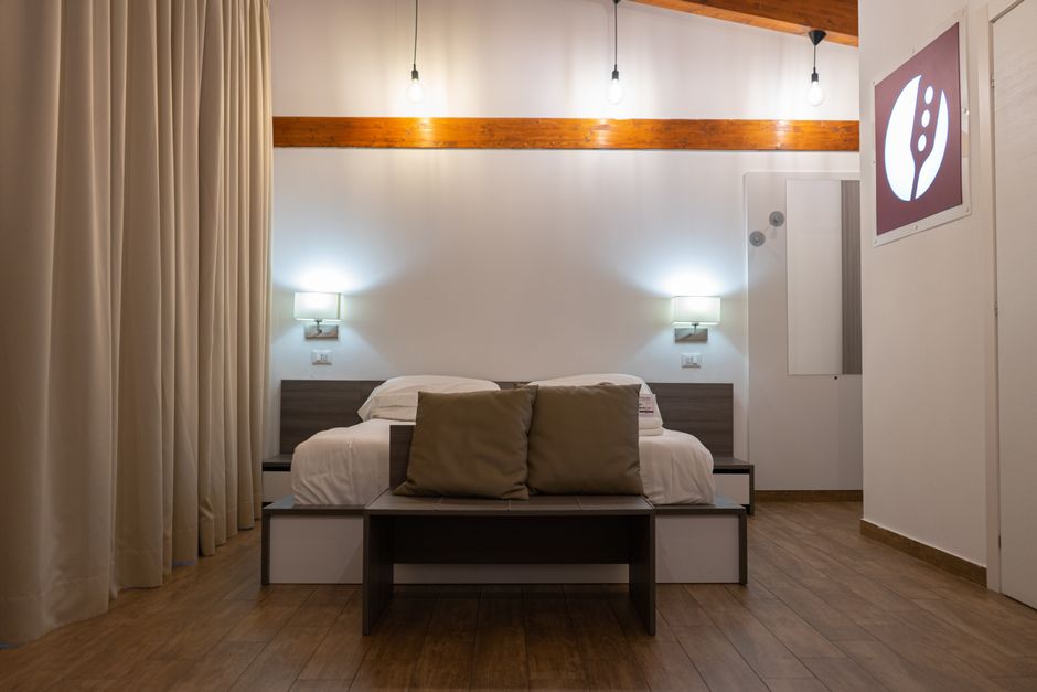 Modern bedroom interior featuring minimalist design, warm lighting, wooden flooring, and neutral tones.
