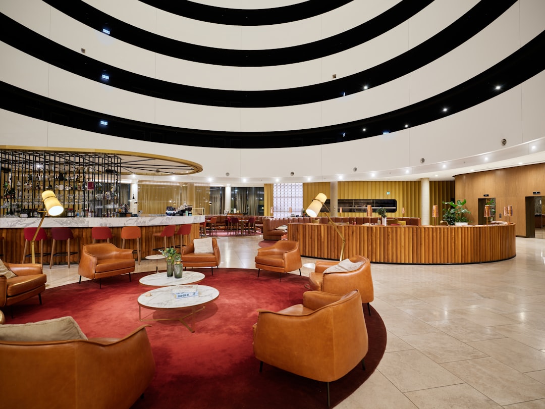 Modern hotel lobby with circular seating and bar area.