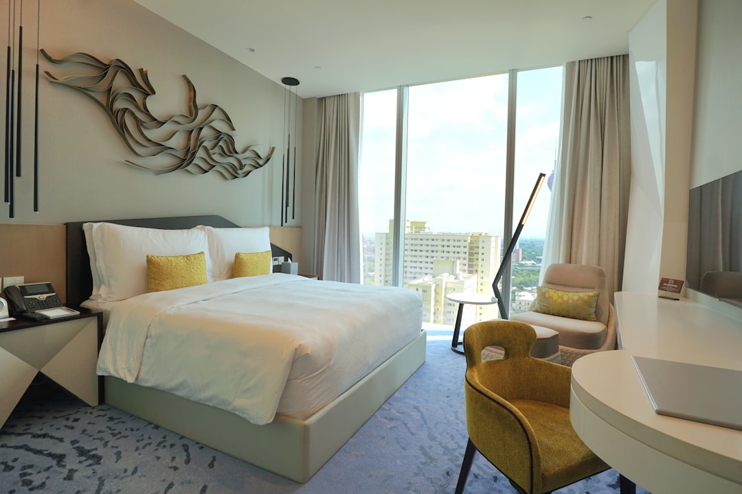 Modern hotel room with a large bed and city view.