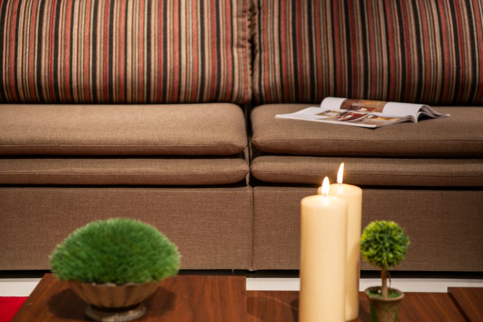 Warm and inviting living room setup with candles, sofa, and plants. Perfect for home decor inspiration.